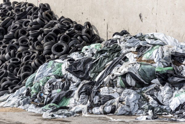 piles of rubber tires and plastic bags at garbage dump